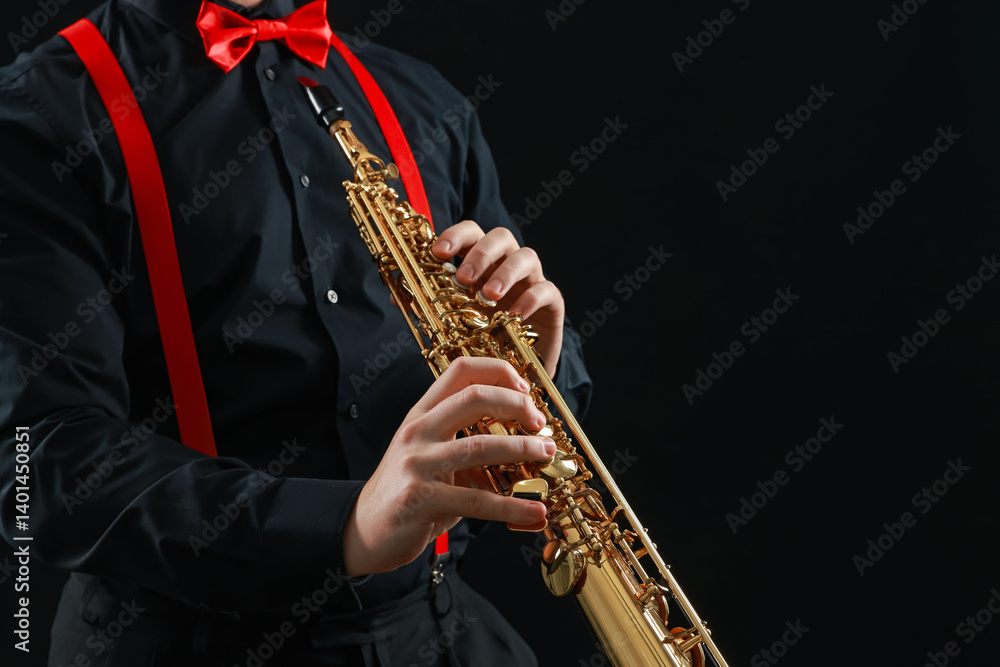 Naklejka premium Professional musician playing soprano saxophone on black background, closeup. Space for text