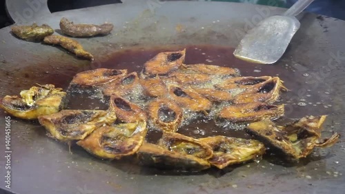 Hilsha fish is fried in a big pan along with shrimp and eggplant, Hilsha Fish and shrimp Simmering in mustard oil, traditional Bengali style fried hilsa and eggplant	