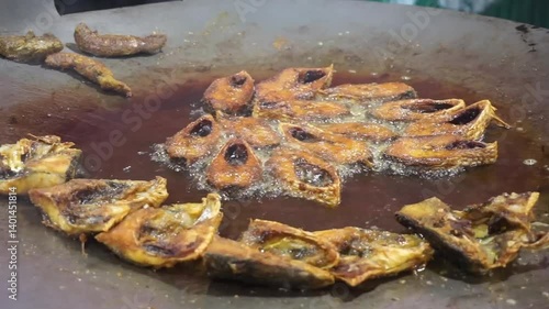 Hilsha fish is fried in a big pan along with shrimp and eggplant, Hilsha Fish and shrimp Simmering in mustard oil, traditional Bengali style fried hilsa and eggplant	
