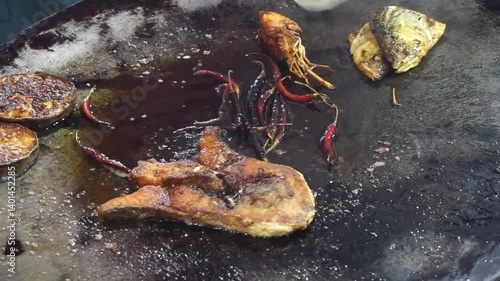 Hilsha fish is fried in a big pan along with shrimp and eggplant, Hilsha Fish and shrimp Simmering in mustard oil, traditional Bengali style fried hilsa and eggplant	