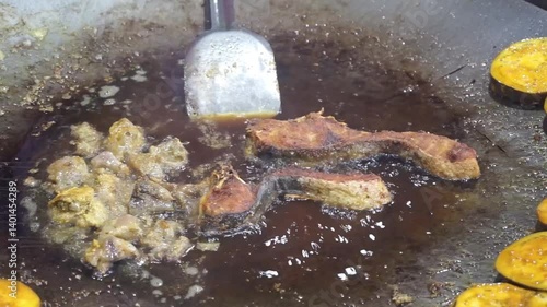Hilsha fish is fried in a big pan along with shrimp and eggplant, Hilsha Fish and shrimp Simmering in mustard oil, traditional Bengali style fried hilsa and eggplant	