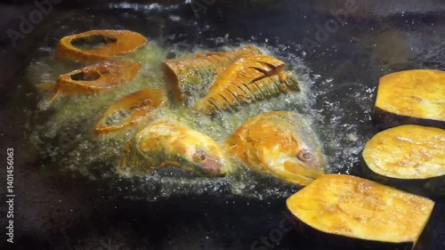 Hilsha fish is fried in a big pan along with shrimp and eggplant, Hilsha Fish and shrimp Simmering in mustard oil, traditional Bengali style fried hilsa and eggplant	