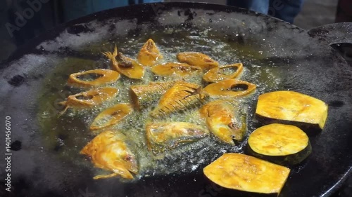 Hilsha fish is fried in a big pan along with shrimp and eggplant, Hilsha Fish and shrimp Simmering in mustard oil, traditional Bengali style fried hilsa and eggplant	