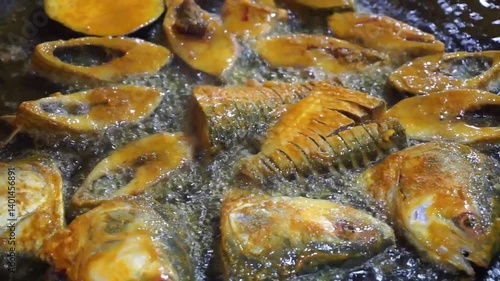 Hilsha fish is fried in a big pan along with shrimp and eggplant, Hilsha Fish and shrimp Simmering in mustard oil, traditional Bengali style fried hilsa and eggplant	