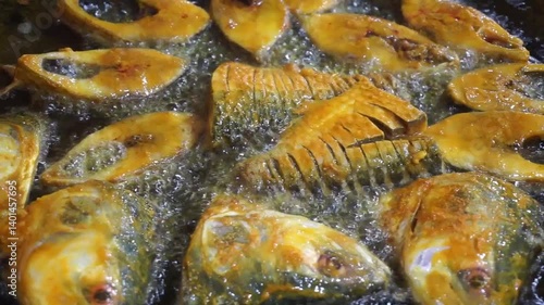 Hilsha fish is fried in a big pan along with shrimp and eggplant, Hilsha Fish and shrimp Simmering in mustard oil, traditional Bengali style fried hilsa and eggplant	