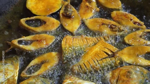 Hilsha fish is fried in a big pan along with shrimp and eggplant, Hilsha Fish and shrimp Simmering in mustard oil, traditional Bengali style fried hilsa and eggplant	