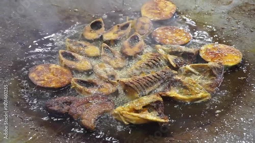 Hilsha fish is fried in a big pan along with shrimp and eggplant, Hilsha Fish and shrimp Simmering in mustard oil, traditional Bengali style fried hilsa and eggplant	