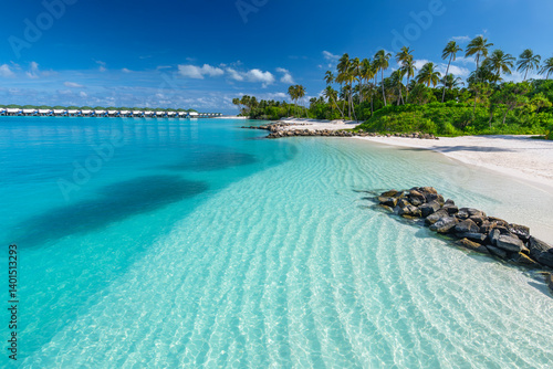 Beautiful tropical beach with white sand, palm trees, turquoise ocean against blue sky with clouds on sunny summer day, island of Maldives.