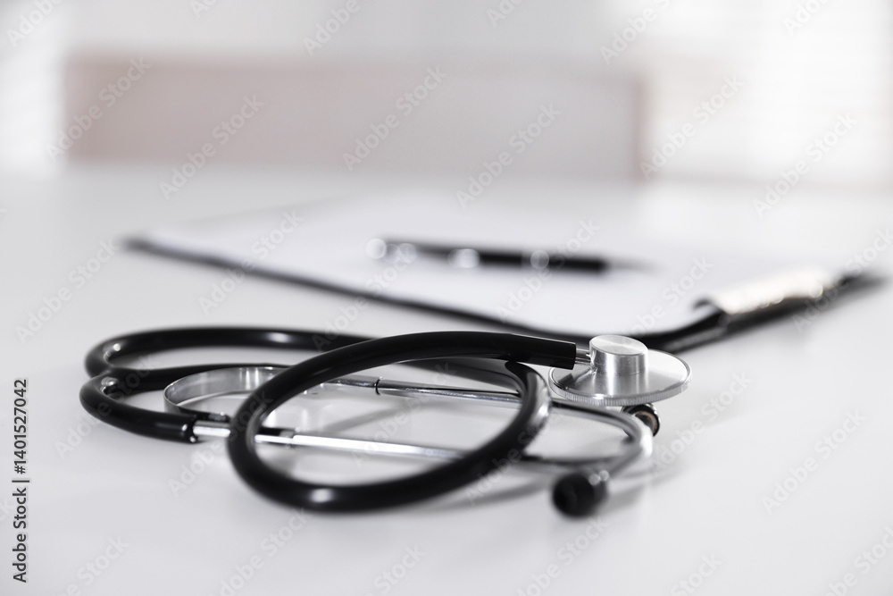 Stethoscope and paperwork on white desk in hospital, selective focus. Space for text Stethoscope and paperwork on white desk in hospital, selective focus. Space for text