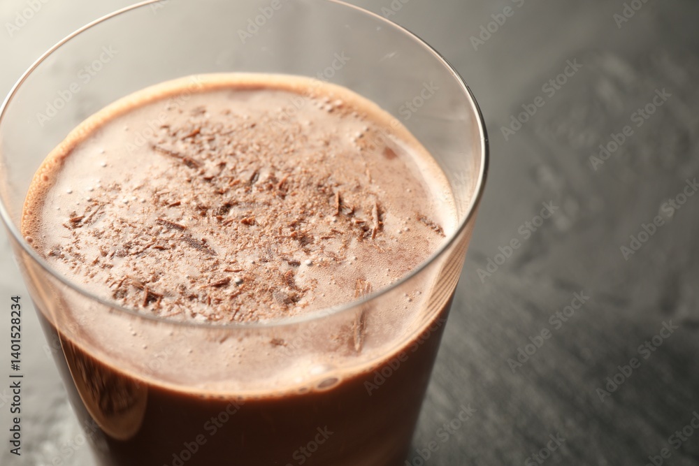 Tasty chocolate milk with shavings on black table, closeup Tasty chocolate milk with shavings on black table, closeup