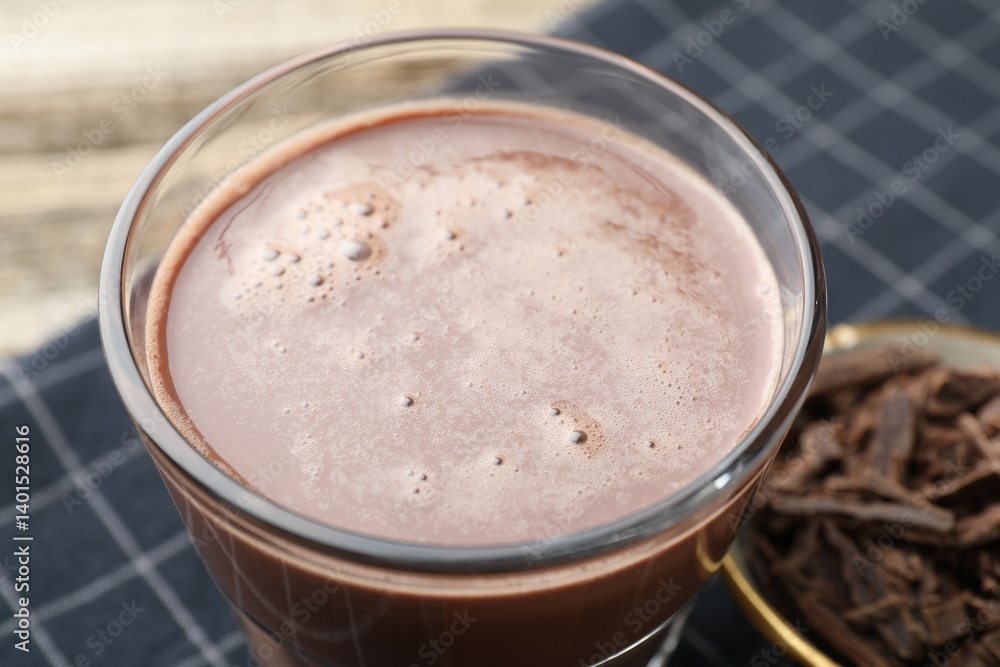 Tasty chocolate milk with shavings on wooden table, closeup Tasty chocolate milk with shavings on wooden table, closeup