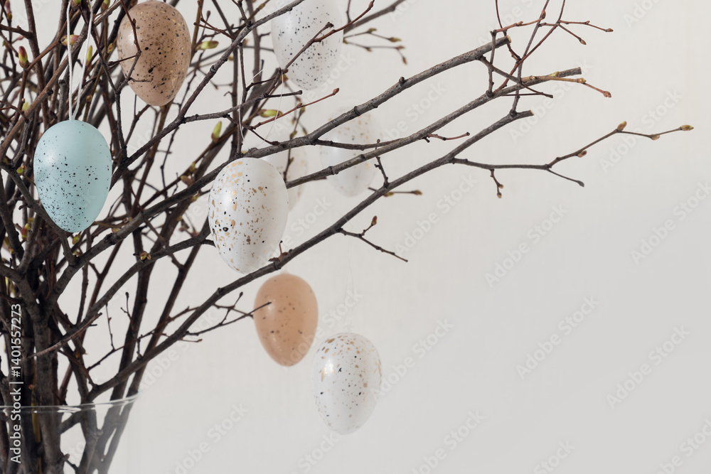 Easter tree decorated colorful pastel white and beige eggs. Birch branches with hang eggs in vase on white background. Close up. Copy space. Greeting card.
