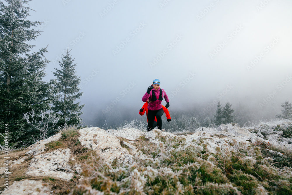 Trail running couple man and woman running on a mountain path