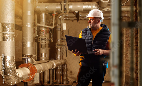 Engineer in a hard hat insp...