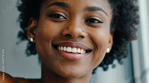 Radiant portrait of a smiling African American woman, showcasing beautiful teeth, healthy skin, and a happy, confident expression.