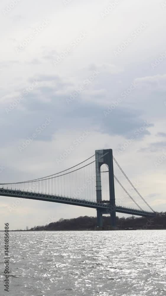 traffic over the verrazzano bridge with water moving in river nyc new york city harbor (cloudy gray overcast day) scenic suspension cables between brooklyn and staten island cars trucks buses driving traffic over the verrazzano bridge with water moving in river nyc new york city harbor (cloudy gray overcast day) scenic suspension cables between brooklyn and staten island cars trucks buses driving