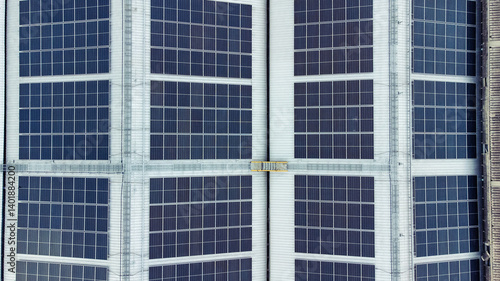 Obraz na płótnie multiple solar panels installed on the rooftop of a building. The solar panels are arranged in neat rows and columns, with clear separations between each panel. w salonie