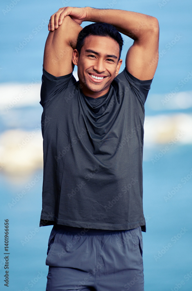 Portrait, arm and man stretching by ocean for warm up before workout or morning training routine for race or wellness. Fitness person, outdoor and exercise for marathon or health, cardio and sports.
