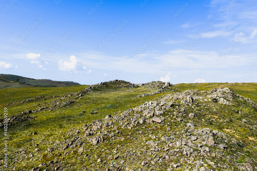 Khakassia. Old stone wall. Mountain landscape with blue sky Khakassia. Old stone wall. Mountain landscape with blue sky