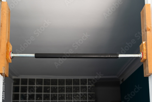 Wallpaper Mural Simple pull-up bar, securely installed in a doorway for home strength training and fitness. Torontodigital.ca