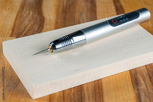 A close-up of an engraver tool, designed for carving into wood and metal. Detailed sharp, precision-focused.