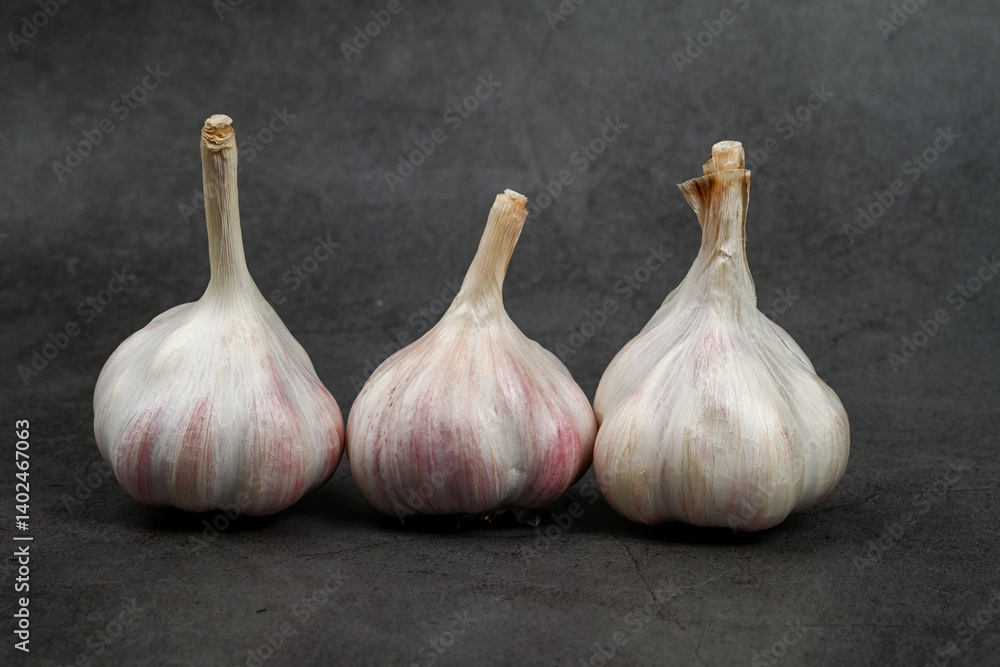Obraz premium Fresh Garlic Bulb with Peeling Skins. purple garlic. Suitable for cooking, health, food introduction, nutrition topics.