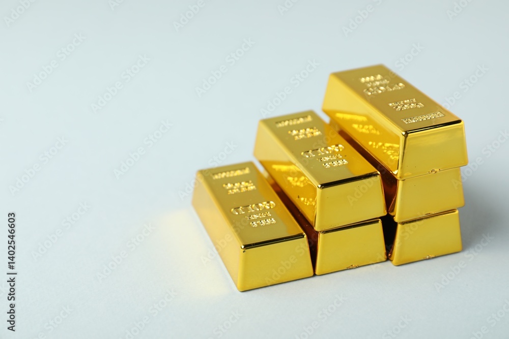Shiny gold bars on light background, closeup. Space for text Shiny gold bars on light background, closeup. Space for text