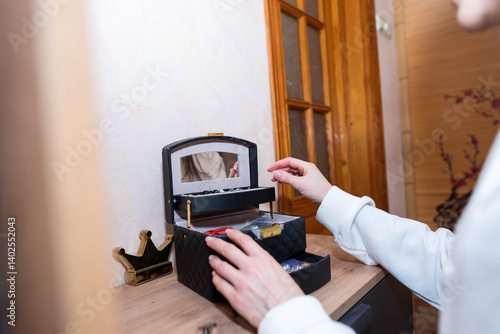 Young woman with long dark hair choosing jewelry from an organizer