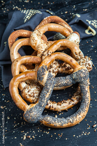 Obraz na płótnie Fresh prepared homemade soft pretzels. Different types of baked pretzels with seeds on a black background w salonie