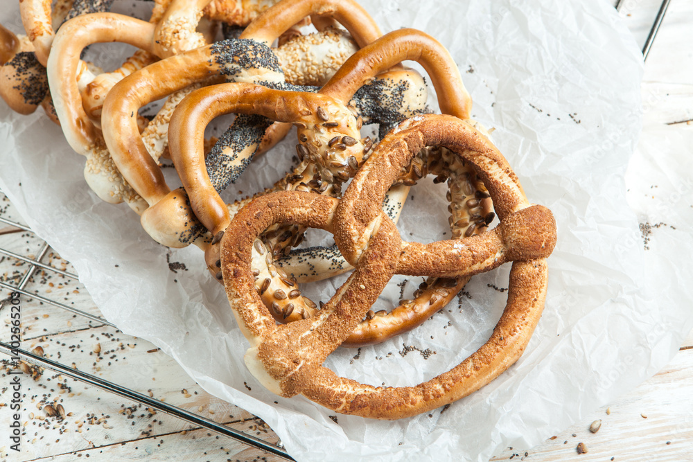 Fresh prepared homemade soft pretzels. Different types of baked pretzels with seeds on a black background