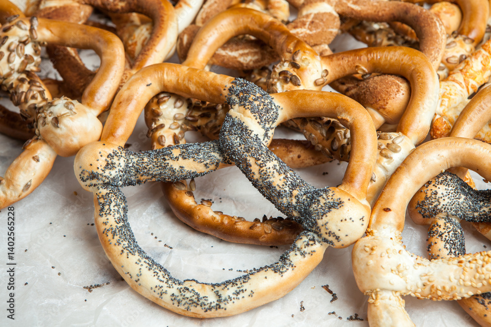 Fresh prepared homemade soft pretzels. Different types of baked pretzels with seeds on a black background