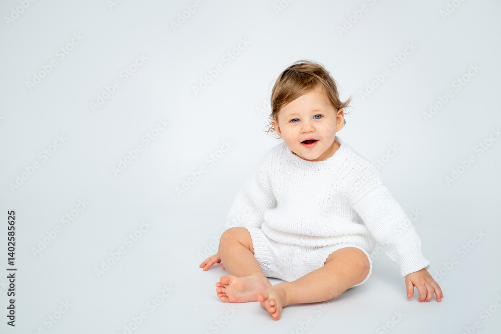 A baby boy on a white isolated background with a place for text is sitting in white knitted clothes. A small happy child in a winter sweater , space for text A baby boy on a white isolated background with a place for text is sitting in white knitted clothes. A small happy child in a winter sweater , space for text