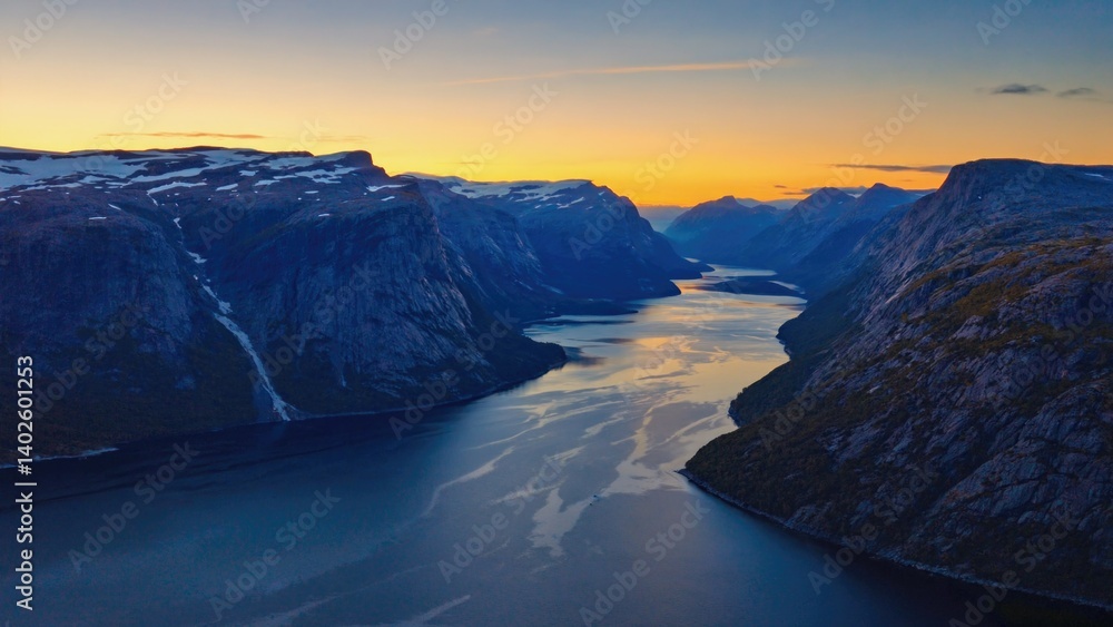 The tranquil waters of a fjord reflect the colors of the sky during sunset in Norway.