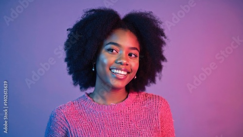 Obraz na płótnie Young woman with large afro smiling, wearing pink sweater against purple background w salonie