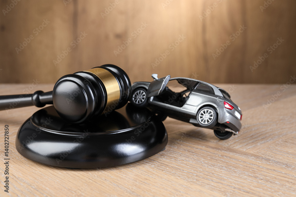 Motor vehicle accident law. Gavel and car model on wooden background, closeup Motor vehicle accident law. Gavel and car model on wooden background, closeup