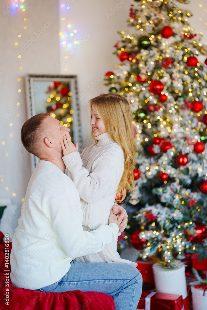 Father and teenage daughter at the Christmas tree.