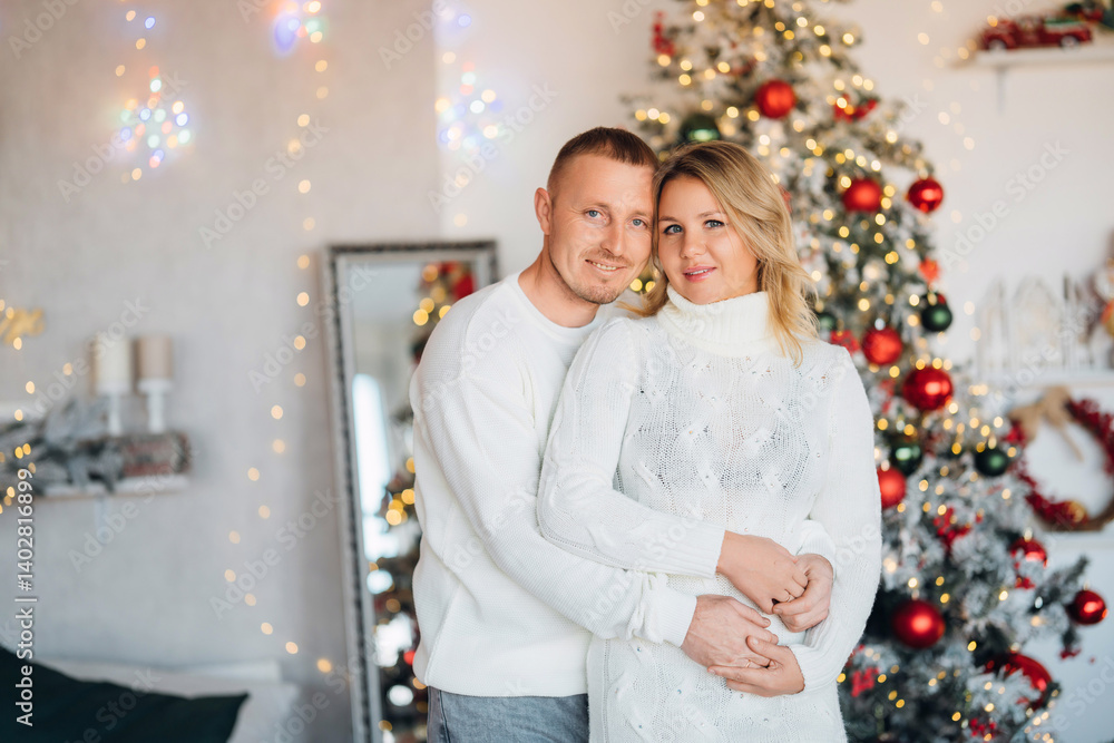 happy man and woman in a room with a Christmas tree.