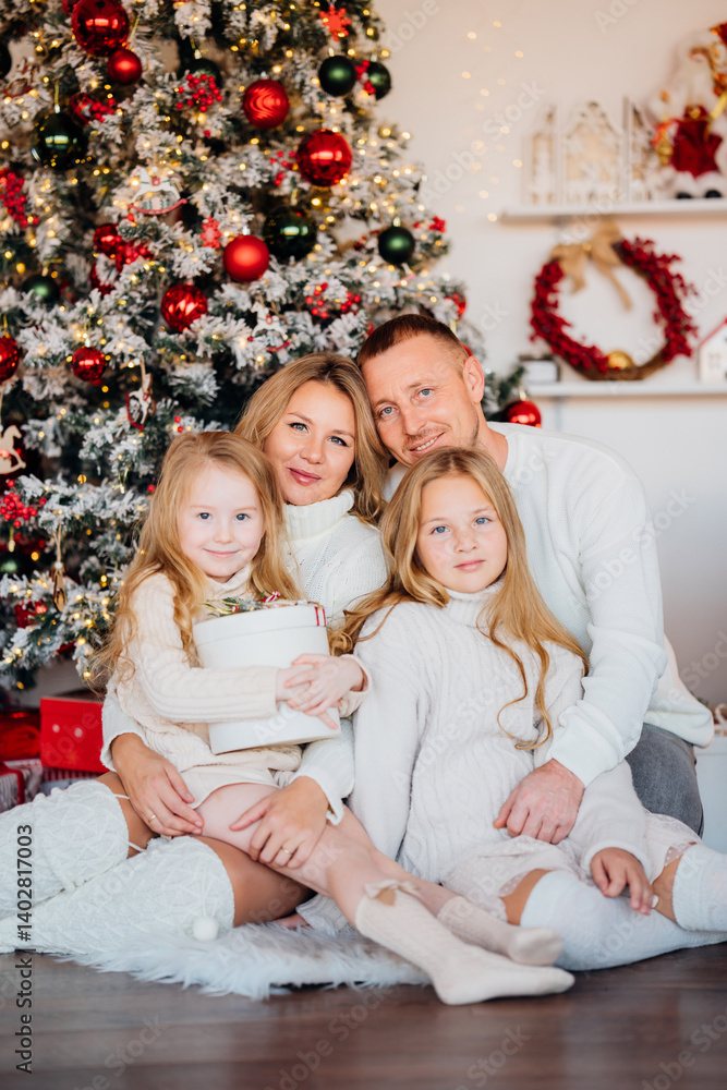 A beautiful and happy family at the Christmas tree at home