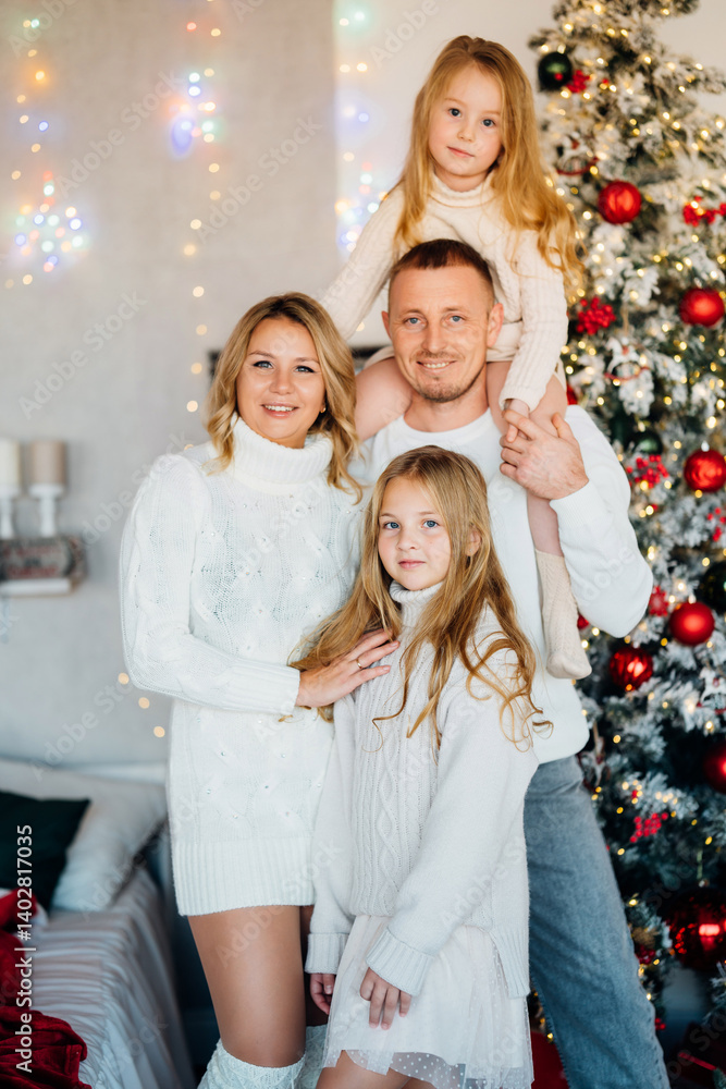 A beautiful and happy family at the Christmas tree at home
