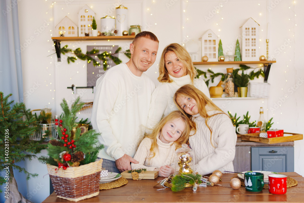 A beautiful and happy family at the Christmas tree at home in the kitchen.