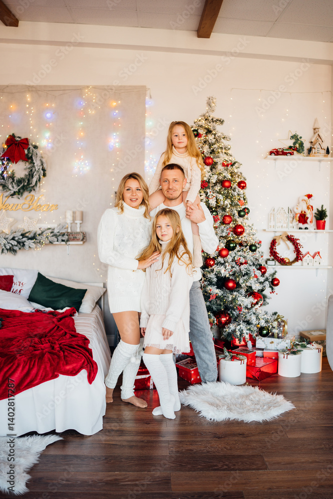 A beautiful and happy family at the Christmas tree at home