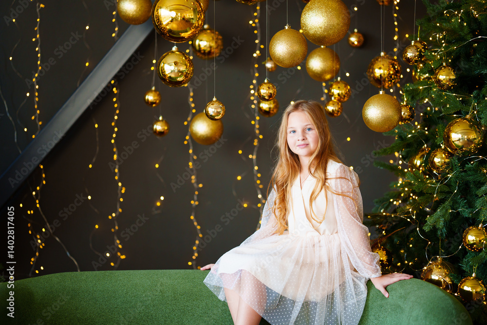 Happy beautiful little girl in a fancy dress in a room with new year decor.