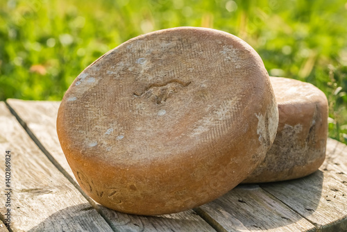 Traditional Ossau-Iraty cheese on a wooden table in the rural setting in France.