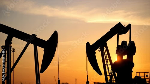 Silhouette of Oil Worker at Sunset with Pump Jack Machinery