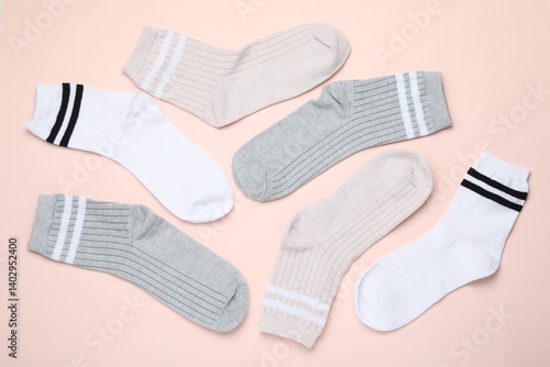 Many different pairs of socks on beige background, flat lay