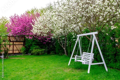 Colorful garden with swing set surrounded by blooming flowers in a sunny park setting