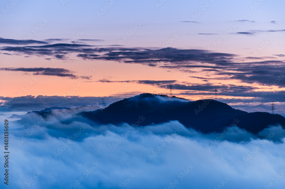 A serene spring dawn at Lion Head Mountain, Taiwan. Orange skies meet flowing white clouds, with silhouettes of power line towers. A serene spring dawn at Lion Head Mountain, Taiwan. Orange skies meet flowing white clouds, with silhouettes of power line towers.