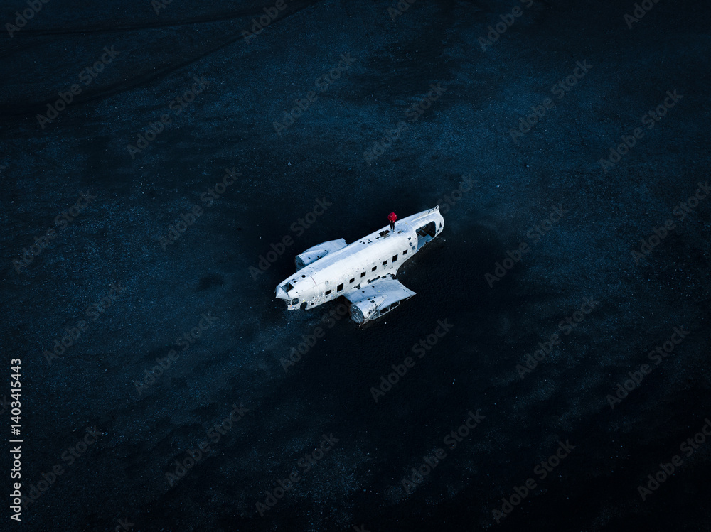 On Iceland’s stark black sands, a stranded DC-9 wreck stands out. The figure perched atop its fuselage adds a sense of scale, so seamlessly blending human curiosity with nature's rugged, moody allure.