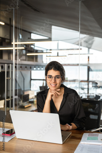 Wallpaper Mural Vertical portrait of indian or middle eastern businesswoman looking at camera. Smiling professional manager using pc at workplace. Latin hispanic business woman working on laptop computer in office Torontodigital.ca