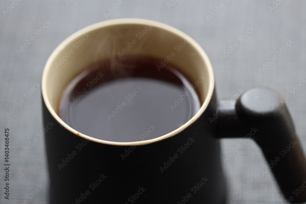 A warm cup of coffee with steam rising from the surface, ready for a cozy morning.